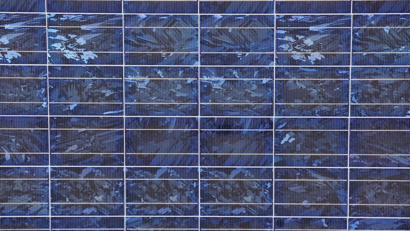 Nahaufnahme von Photovoltaikzellen, dunkelblaues geometrisches Rasterrelief